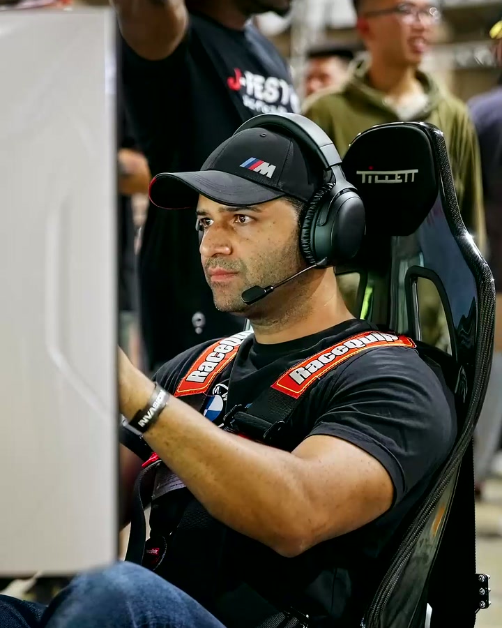 A BMW enthusiast racing in a full-motion simulator at Bimmer Invasion