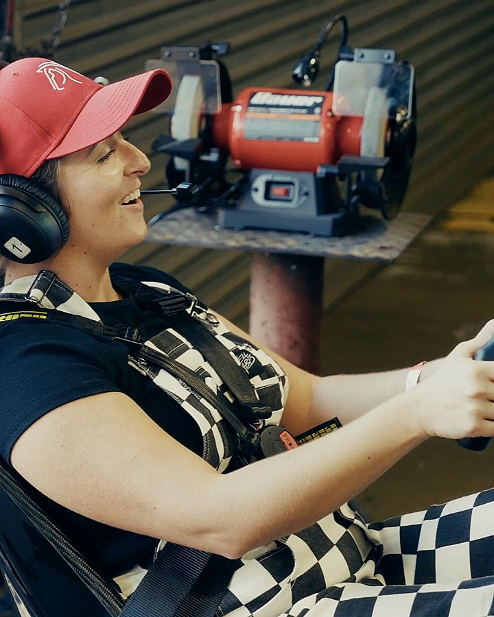A guest laughing at the wheel of a Trackside full-motion simulator at the fundraiser