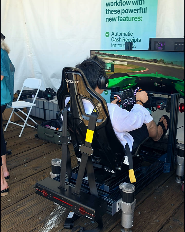 An insurance leader at the wheel of a Trackside full-motion Formula 4 simulator in the Epay Policy footprint