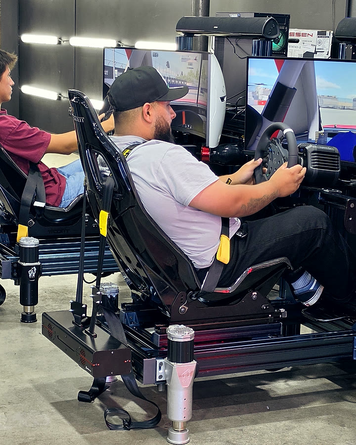 A harnessed driver mid-session on a Trackside full-motion simulator