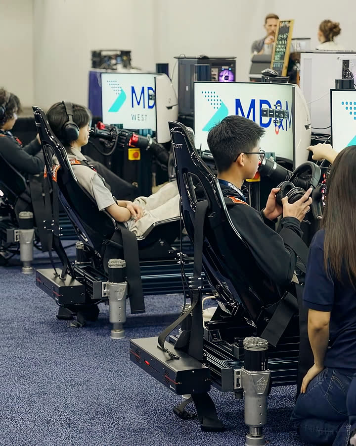 A row of branded Trackside simulators running on a trade-show floor